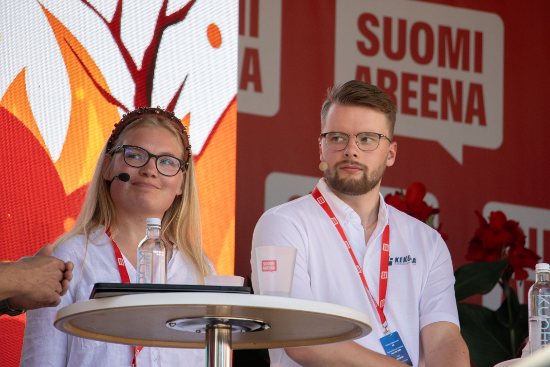 Lavakeskustelijat: nuori, vaaleatukkainen nainen ja tummatukkainen mies SuomiAreenan lavalla.