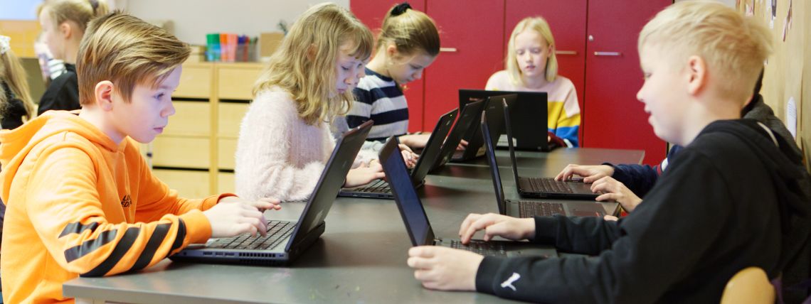 Oppilaita luokassa tietokoneiden äärellä